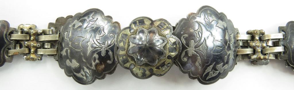 A CAUCASIAN SILVER BELT: Wrought entirely of heavy silver, each piece engraved and nielloed and struck on the reverse with 84 silver mark, some also bear an assayer’s mark dated 1856. The buckle inscribed KABKA3b (Caucasus.