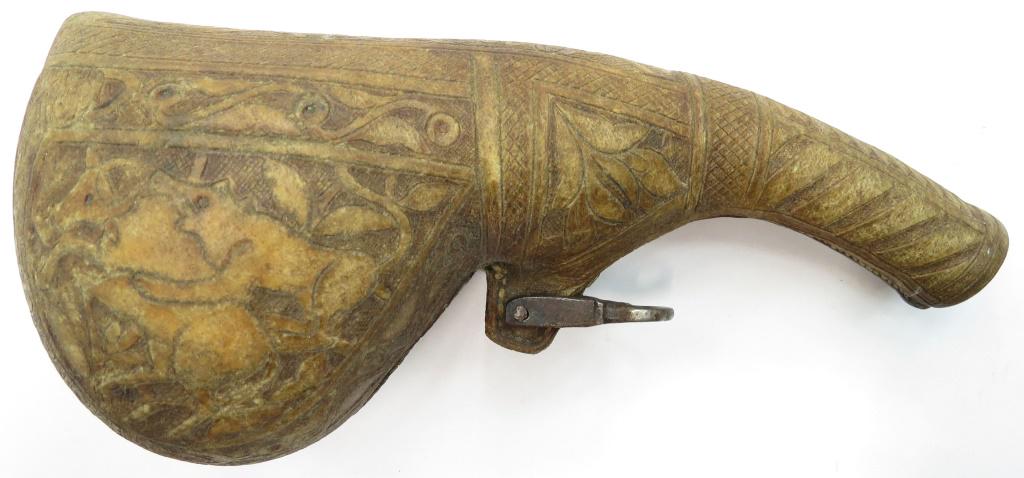 A PERSIAN BARUTDAN POWDERHORN: Of well-tooled rawhide depicting a lion attacking a bull, with steel toggle intact. Mid- 19th century. Overall length 23cm. Condition II