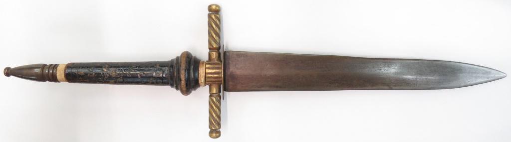 A SPANISH PLUG BAYONET DAGGER: An example of robust construction, with brass guard and pommel and characteristic turned wooden grip. The double-edged blade with central ridge with a maker’s mark at the forte. 19th century. Overal