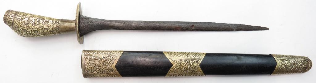 AN INDONESIAN DAGGER: With engraved brass mounts and pamor blade. In its sheath. 19th century. Well worn overall. Overall length43.5cm. Condition III