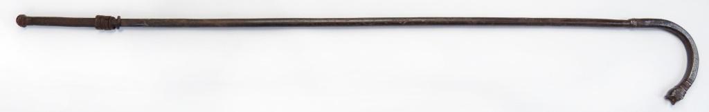 A RARE INDIAN SOTA MACE: A rare type, wrought entirely of steel, the cylindrical haft with expanded, hooked tip, the pommel in the form of a fully-modeled tiger’s head, above geometrical lineal motifs representing tiger str