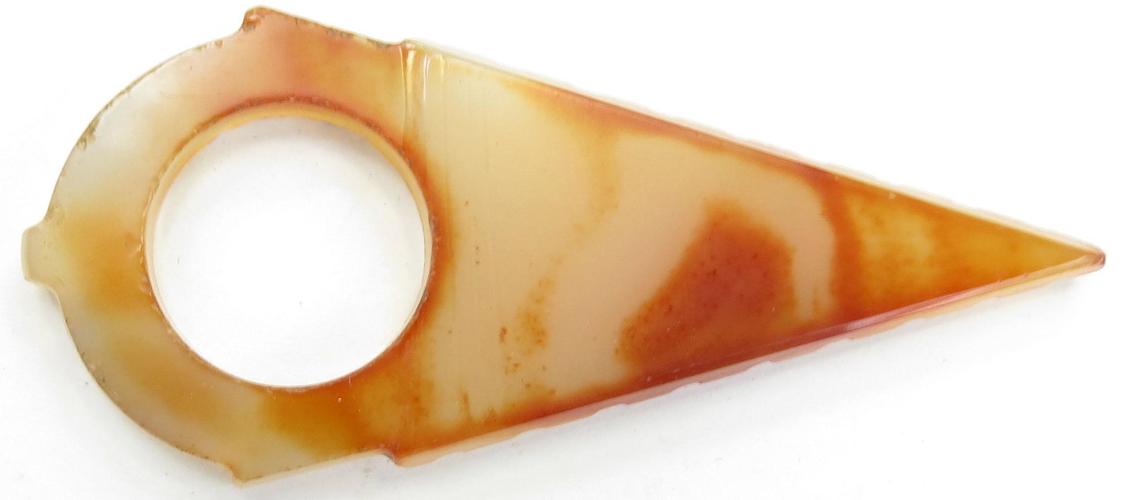 A TUAREG ARCHERS RING: Of characteristic triangular form, handground of carnelian agate and well-polished. 19th c. Overall length 8.5cm. Condition I