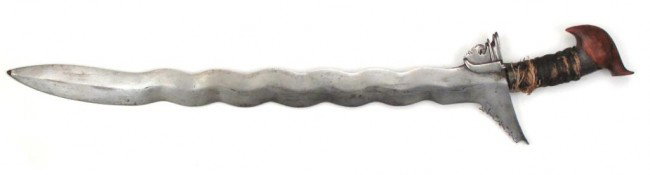 A MORO KAKATUA KRIS SWORD: Kakatua-form hardwood pommel and cord-wrapped grip with baca-baca intact. The substantial 11-waved blade forged with a separate ganja. Minor areas of oxidation to blade, wrap raveled in one area. Four