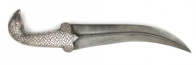 AN INDIAN KHANJAR DAGGER: A massive example with iron grip terminating in a bird's head and covered entirely in silver inlay in an alternating floral and diaper pattern. The lightly curved, double-edged blade with strong centr
