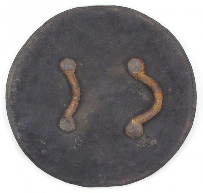 A RARE SCOTTISH TARGE SHIELD: Of characteristic form, the wooden body covered in deeply-patinaed leather, very finely embossed with Celtic interlace work around the periphery and concentric circles to the center, with four small c