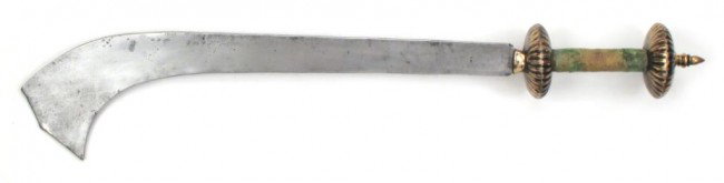 A NEPALESE KORA SWORD: Intended both for warfare and sacrifice, the hilt with pommel and guard in the form of flattened and deeply-fluted brass hemispheres, the cylindrical grip with original velvet covering. Blade of chara