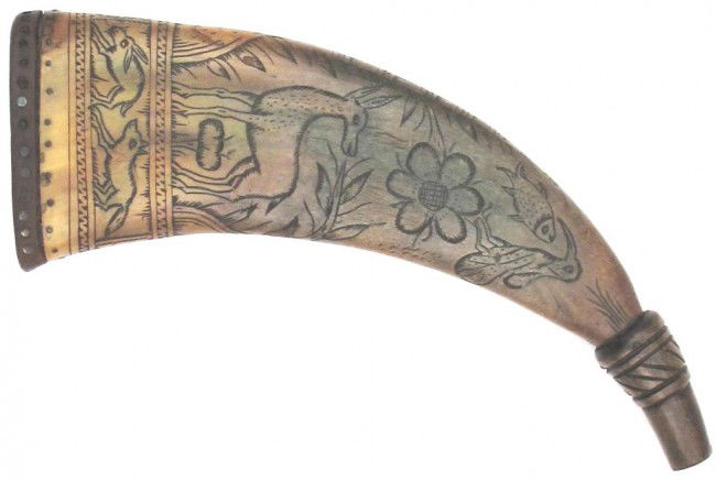 A GERMAN POWDERHORN: Of medium brown flattened horn with studded wooden cap inlaid with staghorn panels, the body well carved overall with flowers, birds, fish and animals between geometrical borders and dated 1708. The e