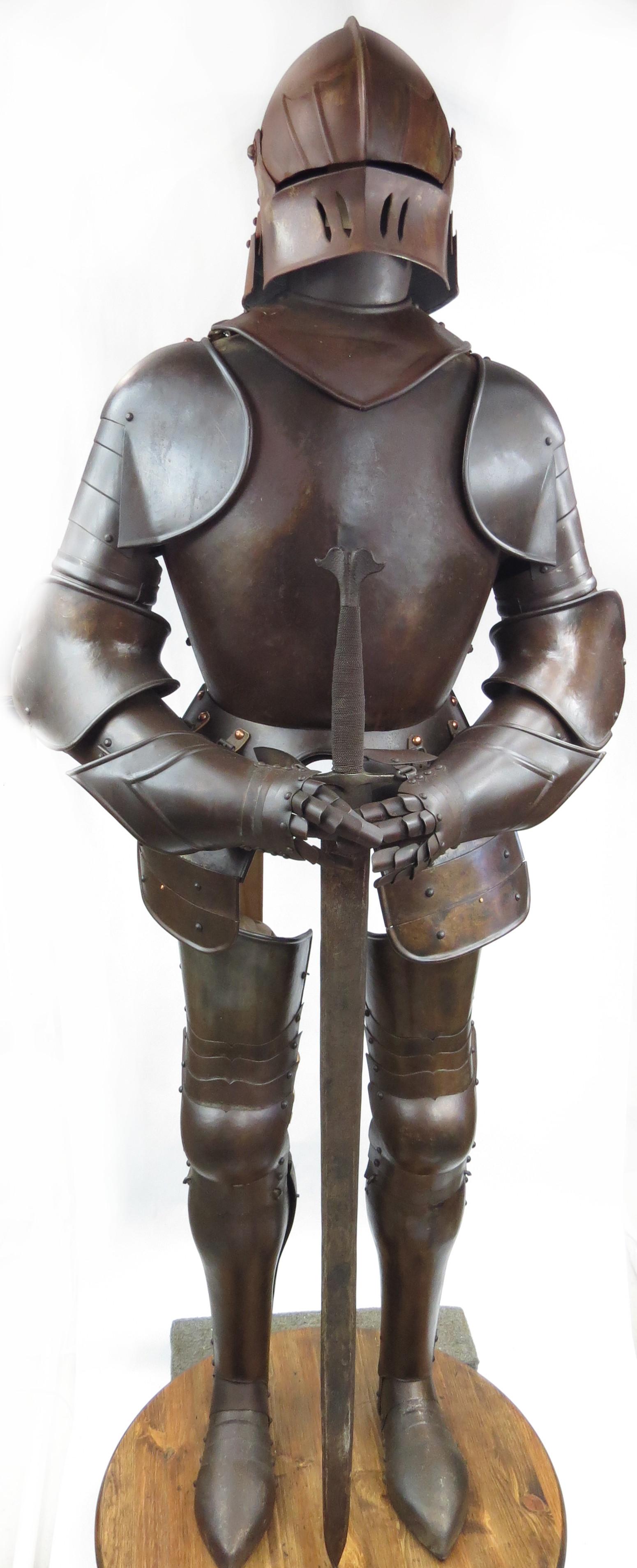 A GEORGIAN-ERA SUIT OF ARMOR: The sallet helmet of characteristic form with central ridge and pivoting visor pierced for ventilation, with rolled borders. Breastplate with central ridge, rolled borders at the neck and arm gussets