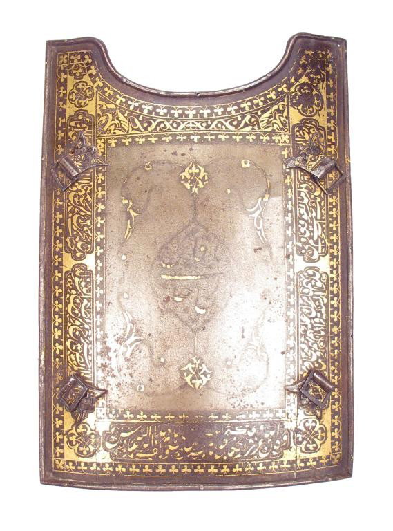 A RARE PERSIAN CHAR AINA ARMOR PLATE: Of unusually high quality, forged of wootz damascus steel with a faint gilt inscription at the center, the borders lavishly inlaid with pious inscriptions in gold. Retains its original fretted and god