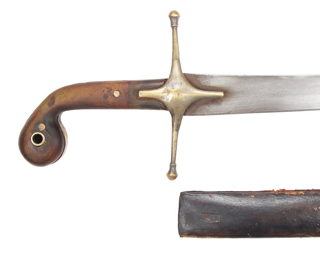 AN OTTOMAN SABER: With horn grips and brass guard, the curved, single-edged blade with narrow fuller and clipped tip, showing traces of wootz damascus steel forging. In its leather covered wooden scabbard with characte
