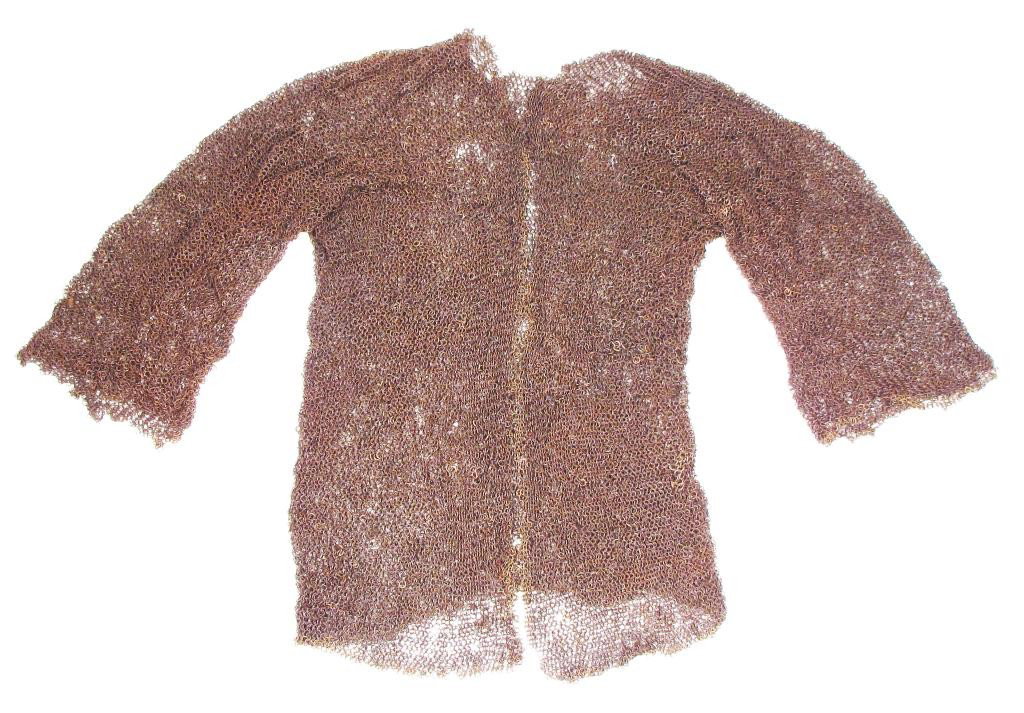 A MUGHAL COAT OF MAIL: Front-opening and hip-length, with long sleeves. The butted rings of small diameter, the opening with brass ring border, with a section of rare punched and riveted theta-links. Mid-17th century.Some l