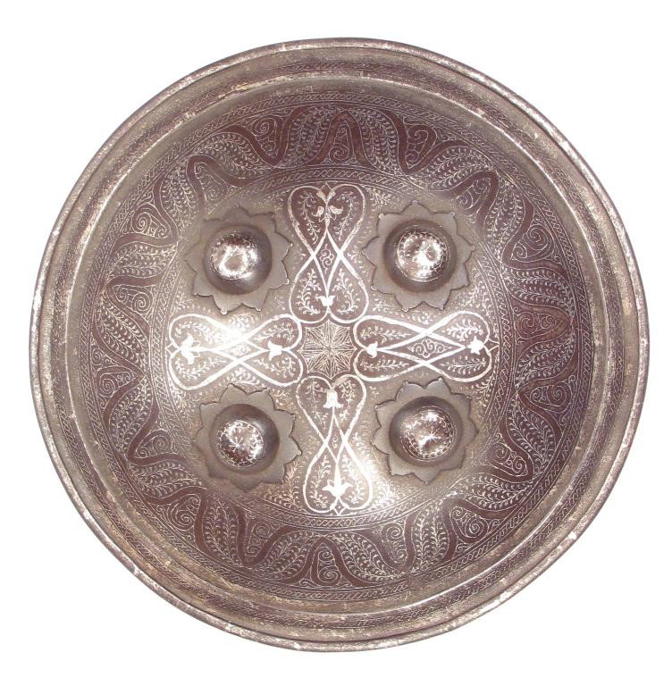 A NORTH INDIAN DHAL SHIELD: A buckler, forged of steel with rolled rim and four profiled bosses, inlaid overall with fine silver inlay involving vinework in geometrical patterns. First half of the 19th century.Losses to lining.D