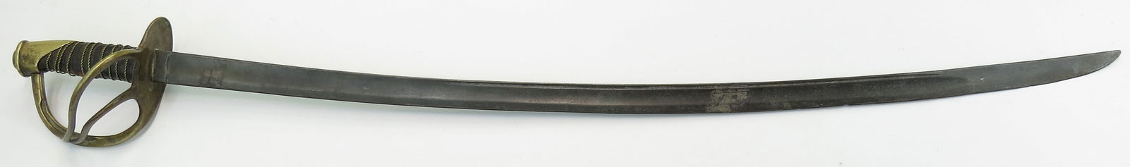 A U.S. M 1860 HEAVY CAVALRY SABER: With characteristic brass pommel and three-branch guard struck 713 on the knucklebow, the leather-covered wooden grip with leather covering retaining its twisted wire wrap. Massive curved and fullered