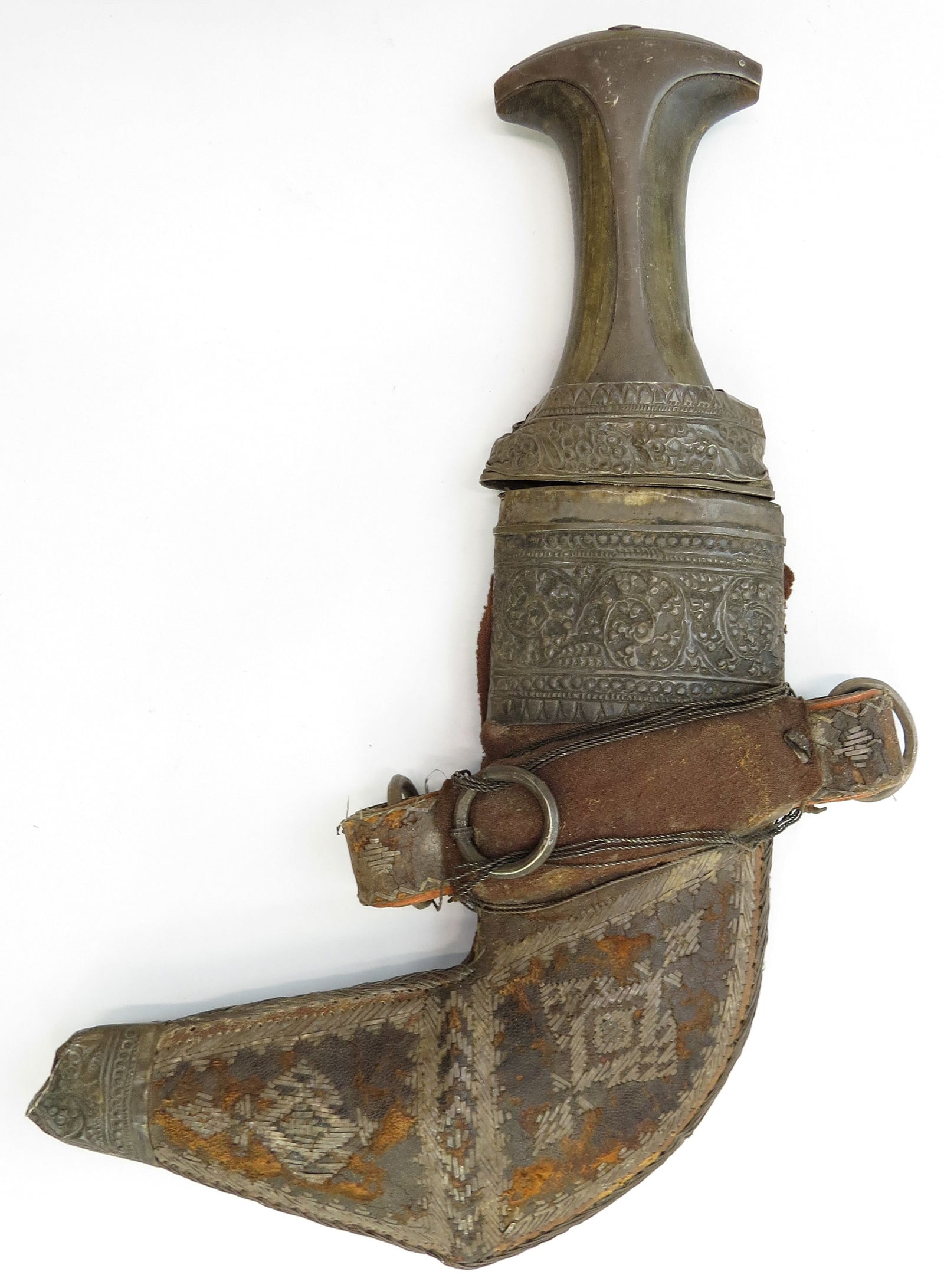 AN OMANI KHANJAR DAGGER: Of characteristic form, the horn grip with flared pommel and engraved silver mounts. The curved, heirloom double-edged blade with central rib, scabbard with engraved silver mounts en suite with the hi