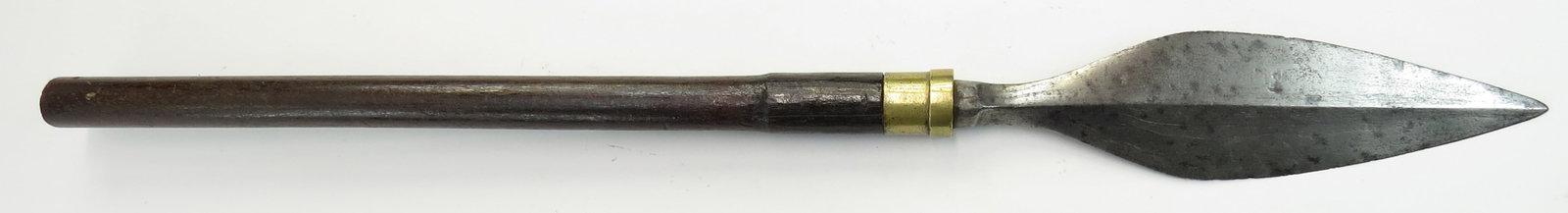 A RARE PHILIPPINES SPEARHEAD: Tausug People, of characteristic leaf-form with central ridge and flared base, well-forged with visible layering. Retains a short section of its kamagong haft with brass ferrule. Second half of the 19