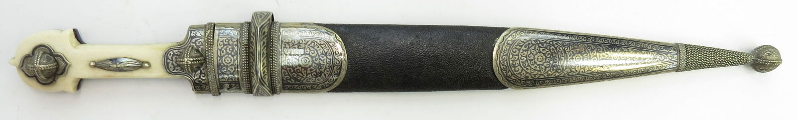 AN IMPERIAL RUSSIAN COSSACK KINDJAL DAGGER: Of characteristic form, the grips of polished antler and horn with elaborately engraved and nielloed silver mounts, the leather-covered wooden scabbard with large silver mounts finely engraved and nie