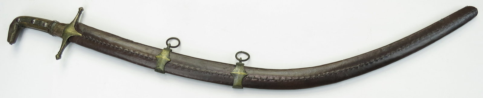A SYRIAN SHAMSHIR SWORD: Mounted in Damascus style, with brass pommel and guard and horn grips. The Persian heirloom blade robust and well-wrought, and appears to show traces of wootz construction. In its leather-covered wood