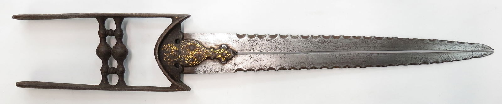 A RARE SOUTH INDIAN KATAR DAGGER: Tanjore work, the hilt of characteristic form, with considerable remains of gold inlay. The straight, double-edged blade divided at the center and deeply serrated along each edge, showing evidence of