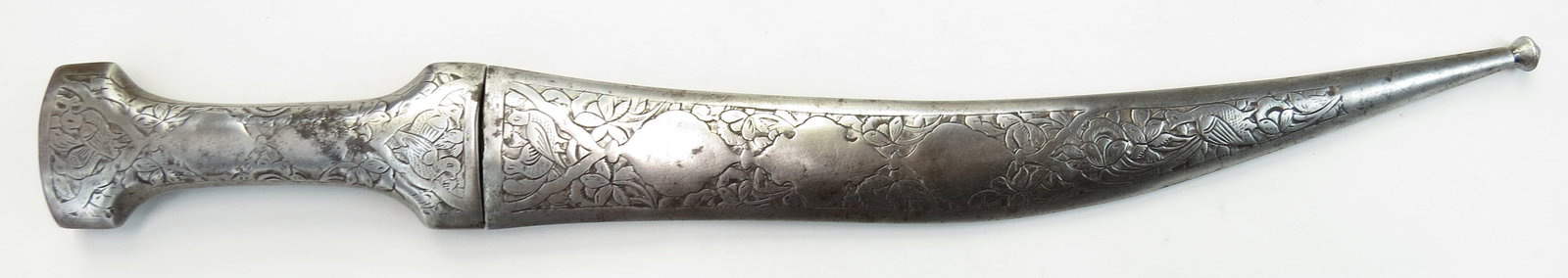 A PERSIAN KHANJAR DAGGER: Wrought entirely of steel, the grip and scabbard and chiseled with vinework. The curved, double-edged blade with engraved panel at the forte. In its en suite chiseled steel scabbard. 19th century. Min