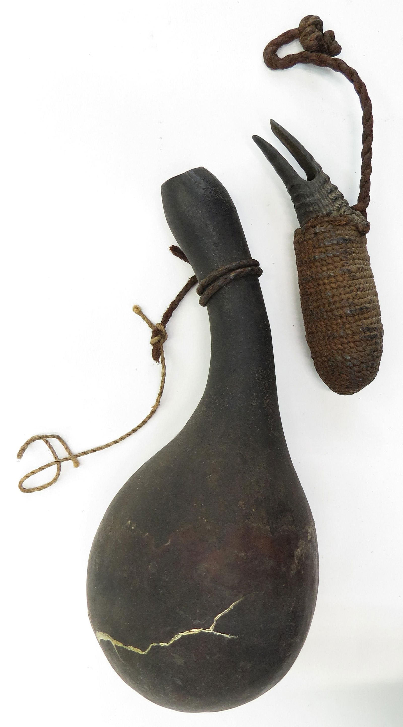 A RARE JAPANESE MATCHLOCK POWDERHORN AND BALL DISPENSER: The horn formed of a dried gourd, the ball dispenser carved of horn, in the form of a crab claw with cord-wrapped body. 17th-18th century. As found. Overall length of horn 23cm / 9?. Condition V