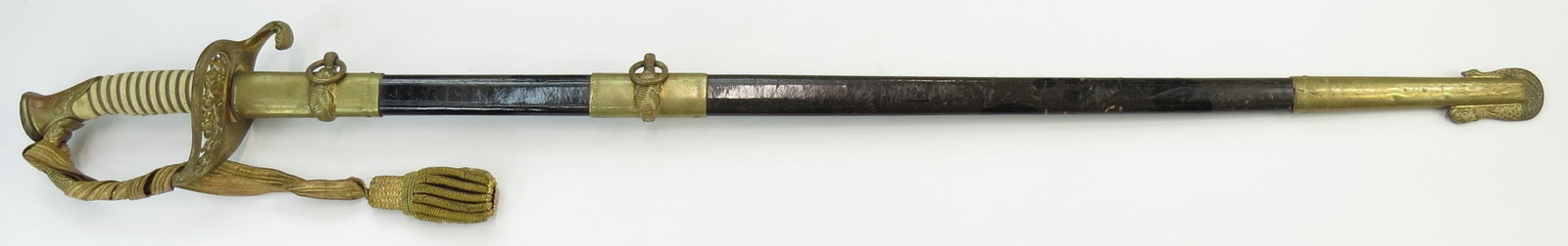 A U.S. NAVAL OFFICERS M 1852 SWORD: The brass hilt of typical form with wire-wrapped sharkskin grip and sword knot, the straight, single-edged blade marked GEMSCO at the forte, with etched panels and a single fuller to either side. Insc