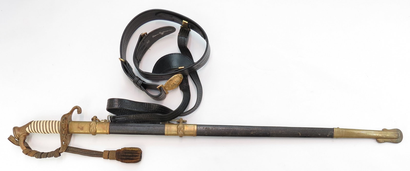 A U.S. NAVAL OFFICERS M 1852 SWORD WITH BELT: The brass hilt of typical form with wire-wrapped sharkskin grip and sword knot, the straight, single-edged blade marked HILBORN HAMBURGER INC, NEW YORK at the forte, with etched panels and a single fu