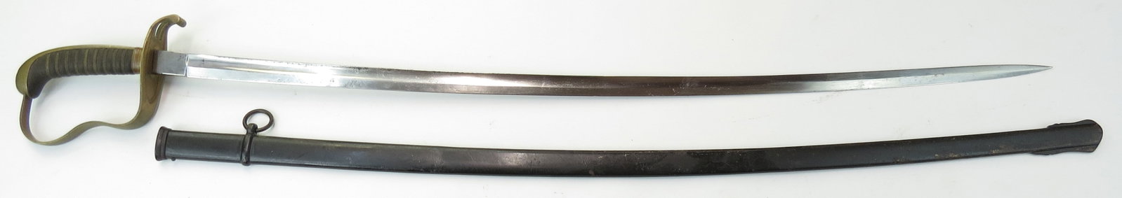 A BAVARIAN M 1855 SABER SWORD: Of characteristic form with brass guard and sharkskin-covered grip with twisted wire wrap intact. With lightly-curved, fullered blade. In its black-painted steel scabbard. 19th-20th century. Minor wea