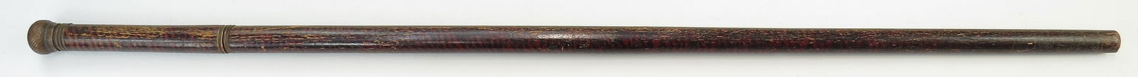 AN AMERICAN SWORDCANE: Civil War era, of hardwood, painted in a curly maple pattern. With brass mounts, the pommel unscrews to reveal a flask or reservoir, and fitted with a straight thrusting blade. In its hardwood haft em