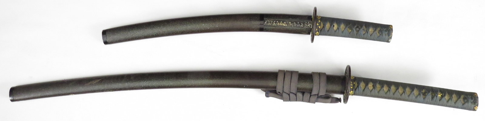 RARE DAISHO PAIR OF JAPANESE SAMURAI SWORDS: Very rarely encountered, a matched pair of Edo Period katana and wakizashi carried by a high-ranking samurai in the Shogunate. Each sword with matched shakudo fuchi and kashira set with numerous Maru 