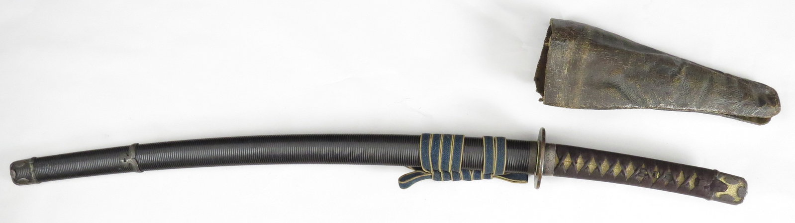 A JAPANESE SAMURAI KATANA SWORD: Late Edo Period, the engraved silver mounts in handachi style, with shakudo menuki in the form of the Three Buddhist Arrows. In its ribbed, black lacquered saya with leather hilt cover intact. The bla