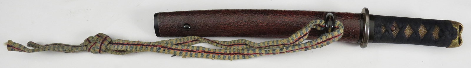 A JAPANESE SAMURAI TANTO DAGGER: Edo era, with gilded kashira and horn fuchi, the tsuba and seppa with substantial remains of gilding. The saya in dark red textured lacquer with horn koiguchi, kurikata and kojiri. Kogatana in place w