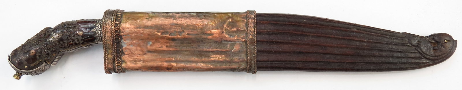 A FINE SRI LANKAN PIHA KAETTA DAGGER: An excellent example of characteristic form, the intricately-carved ebony grip with applied profiled and engraved silver mounts in elaborate scrollwork motifs. The gilded forte inlaid with silver and 