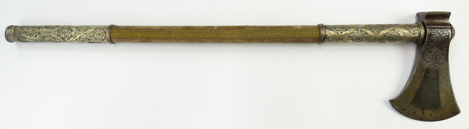A PERSIAN TABARZIN BATTLEAXE: A quality example, the head finely forged of Persian Kara Taban black wootz with panels of gold-inlaid vine motifs. The velvet-covered wooden haft with elaborately embossed brass mounts. Early 18th ce