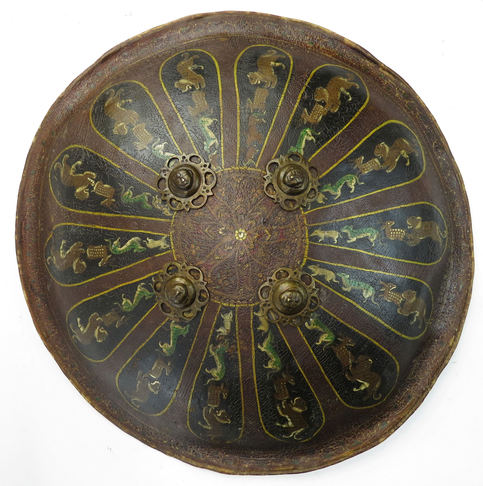 A RARE INDIAN DHAL SHIELD: Rajput work, formed of translucent hide in circular, slightly domed form and brown-lacquered overall. With four bronze pierced bosses, lacquered with 14 lobate cartouches in black with saffron borders