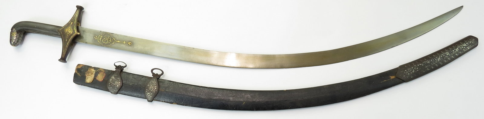 A FINE PERSIAN SHAMSHIR SWORD: With dark horn grips, the finely-wrought steel pommel elaborately inlaid in gold and silver, the guard inlaid with gold. The robust blade of shallow curvature, wrought of superb, actively-grained Pers