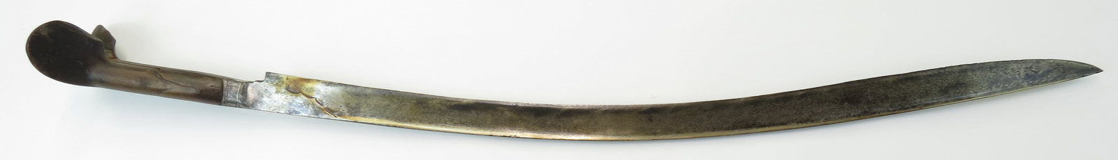 AN OTTOMAN YATAGHAN SWORD: Of considerable length, the horn grips with large ears. The massive blade finely forged of actively-patterned ribbon damascus steel. Well worn, blade pitted, ears chipped. Overall length 82.2cm / 32 1