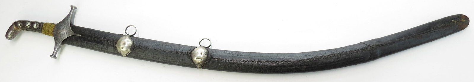 A SYRIAN SHAMSHIR SWORD: Characteristic of swords mounted in Ottoman Damascus, an earlier example with steel guard and studded horn grips set with silver studs and steel pommel with gilt braid wrap to base. Mounted with a fin