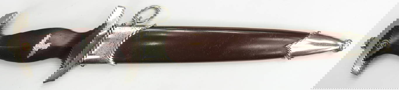 A GERMAN WWII SA DAGGER: Of characteristic form with wooden grip and plated mounts, the blade with etched motto. In its scabbard with en suite mounts. 20th century. Possibly postwar, mounts rubbed. Overall length 37.6cm. / 14