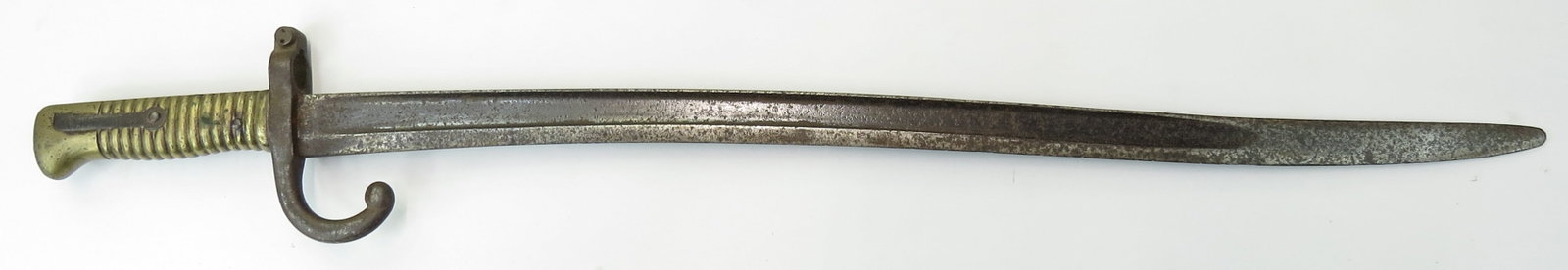 A FRENCH M 1866 CHASSEPOT BAYONET: With brass grip and recurved blade. 19th century. Well worn overall. Overall length 68.6cm / 27 inches. Condition IV