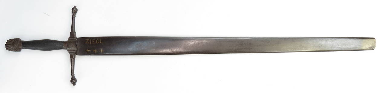 A RARE GERMAN EXECUTIONERS SWORD: A rare and iconic sword, the steel pommel wrought with scallop shell design, the long guard with expanded ecusson, one chiseled 1699, and knobbed quillon terminals, with wooden grip. The broad, lentic