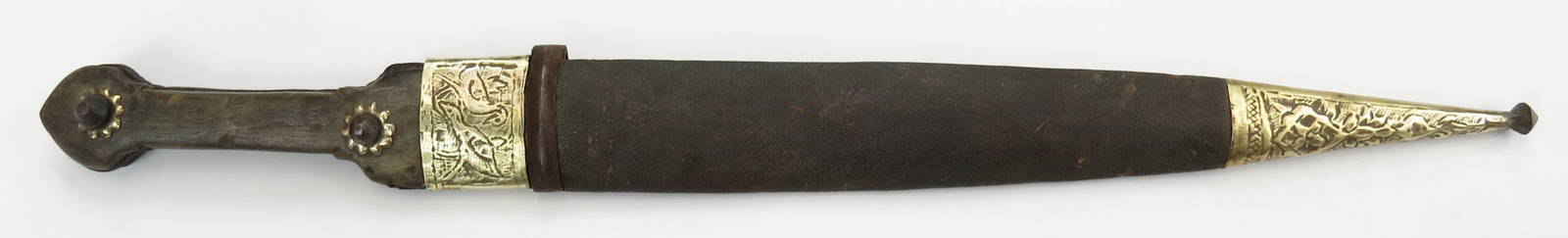 A PERSIAN QADDARA SWORD: Qajar Dynasty, with horn grips and brass mounts. The massive blade straight and double-edged, with offset fullers. In its leather-covered wooden scabbard with engraved brass mounts and steel suspensio