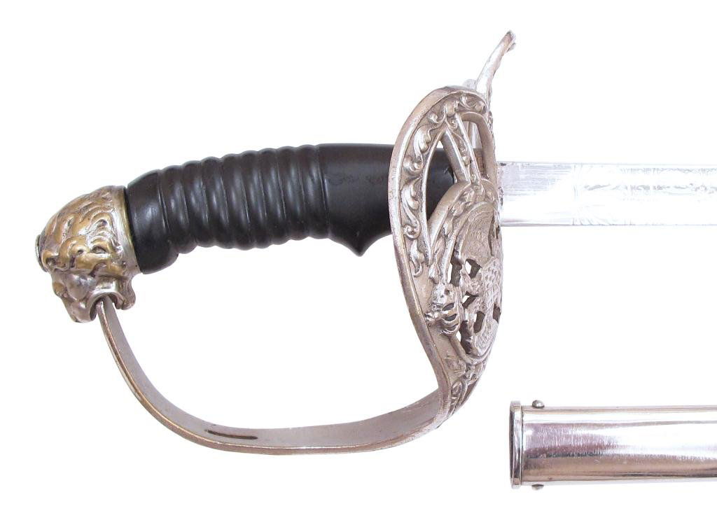AN OTTOMAN OFFICER’S SABER: German made, based upon the M1889 saber, with lionhead pommel, ribbed grip and elaborate guard. Blade with etched crescent moon and star.In its steel scabbard .Early 20th century. Light wear. Overall