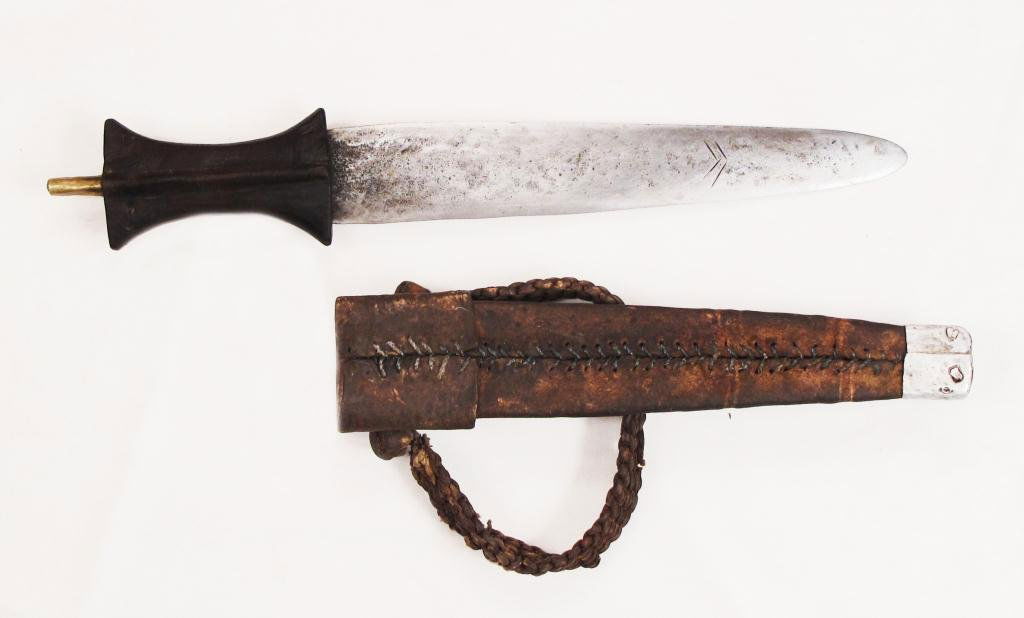 A SUDANESE ARM DAGGER: A large example with hardwood handle and broad blade, the leather scabbard with braided armband. Late 19th century .Overall length 42.2 cm. Condition III