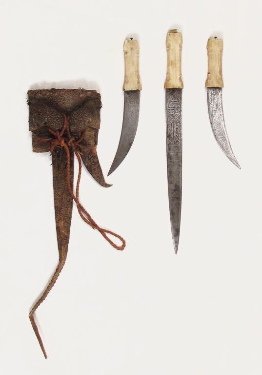 A SUDANESE TRIPLE DAGGER: Mounted and decorated en suite, with one straight and two curved blades, each with stepped bone grips, the blades with elaborate etched Arabic inscriptions, including NASR MIN ALLAH! [Victory from God