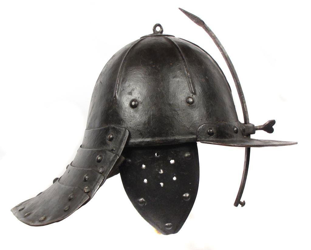AN ENGLISH LOBSTERTAIL BURGONET HELMET: The domed, ribbed bowl well-forged and surmounted by a ring, the visor, earpieces and four-lamed neck guard separately-applied, each with rolled edges.The nasal with flared upper terminal, retained by