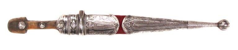 A CAUCASIAN KINDJAL DAGGER: With horn grips mounted in nielloed silver, the straight, double-edged and fullered blade with acute tip. In its velvet-covered wooden scabbard with large, nielloed silver mounts en suite with the hil