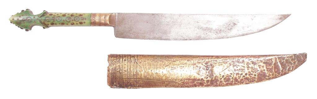 A BOSNIAN DAGGER: The green-stained horn grip with peaked pommel, elaborately profiled and inlaid with brass studs and rosettes, with broad, single-edged blade. In its brass-covered wooden scabbard.Mid-19th century. We