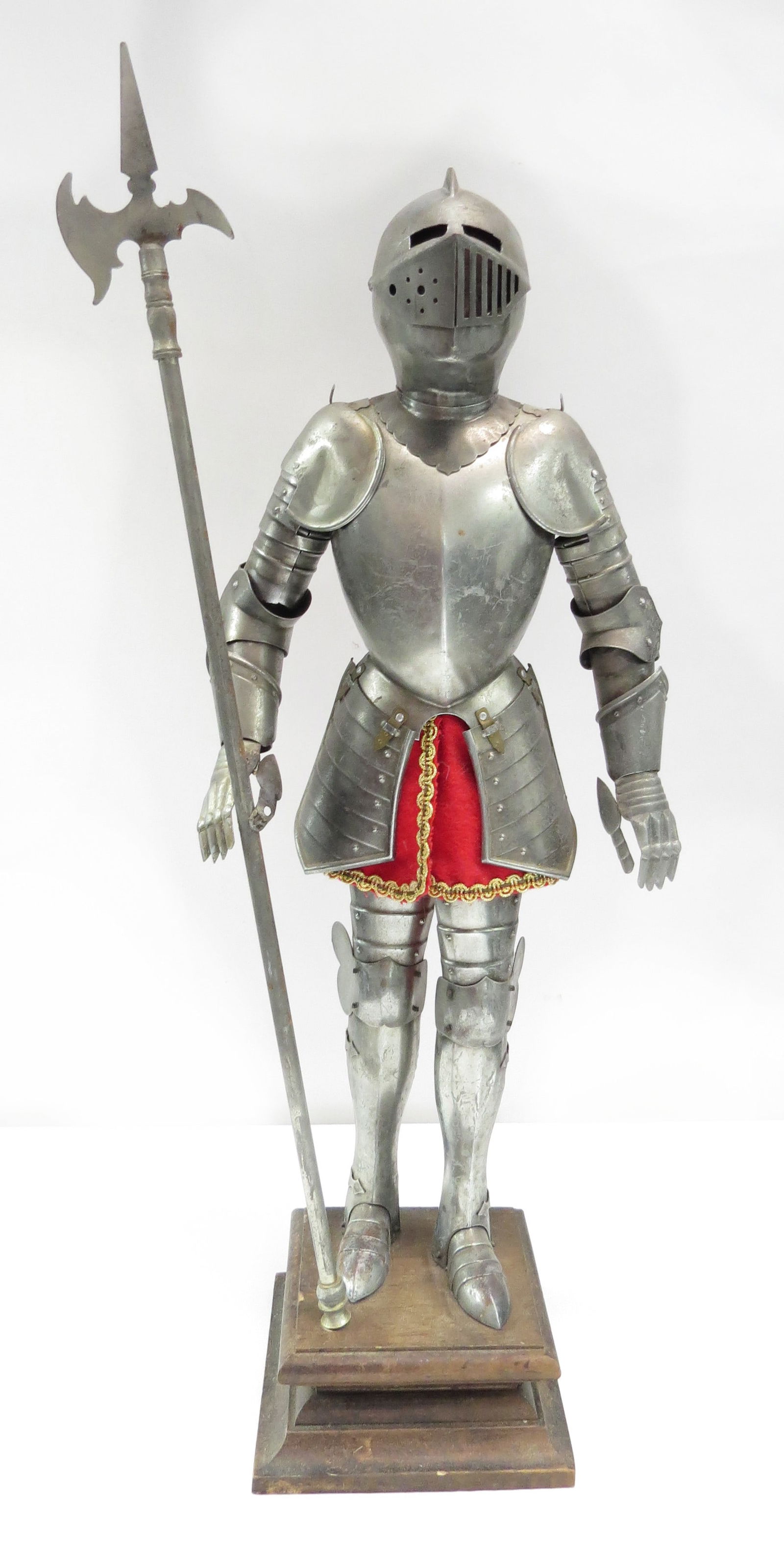 A MINIATURE SUIT OF ARMOR: In the Spanish style, handwrought, each well-detailed steel plate finely detailed and articulated, with velvet and gilt braid accents. Functional visor. On its wooden stand with halberd. 20th century.