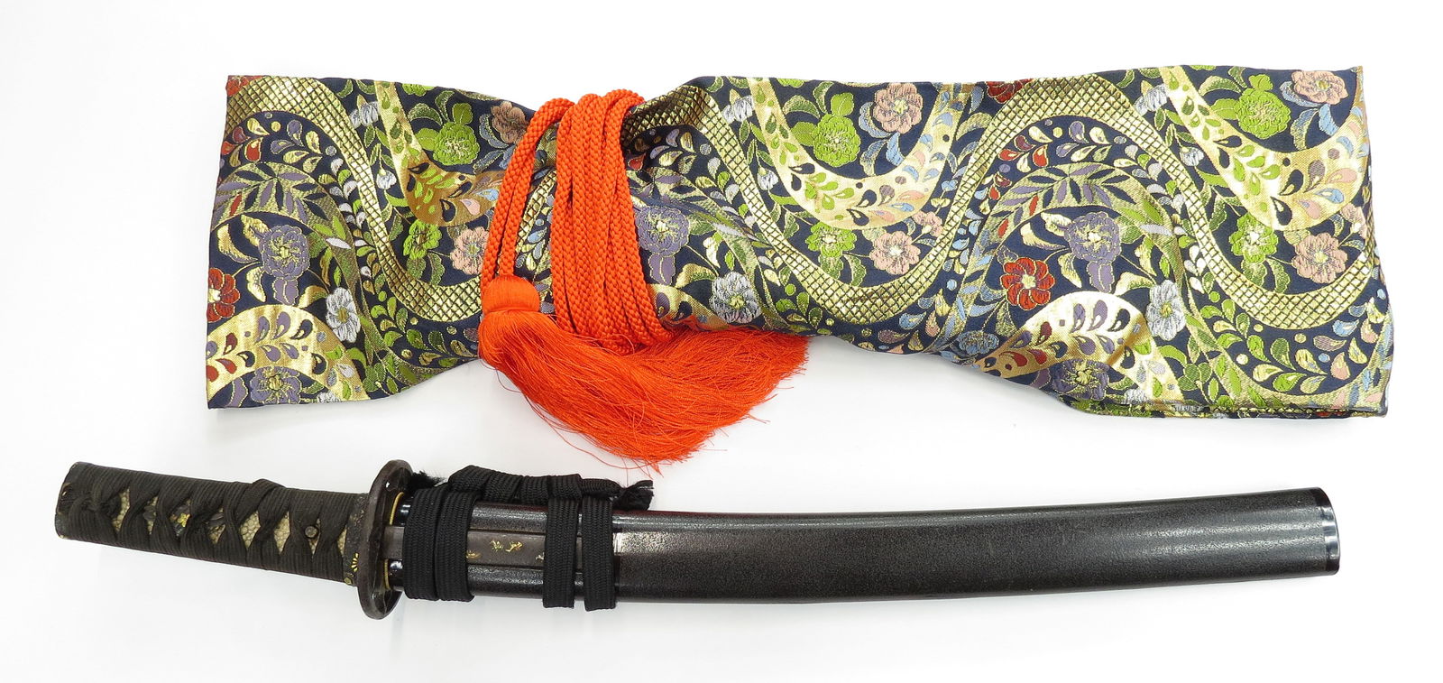 A JAPANESE TANTO DAGGER: With black tsuka ito and shakudo fuchi and kashira in floral motifs elegantly inlaid with gold, the iron sukashi tsuba with clover leaf, the seppa with substantial remains of gilding. Black lacquered