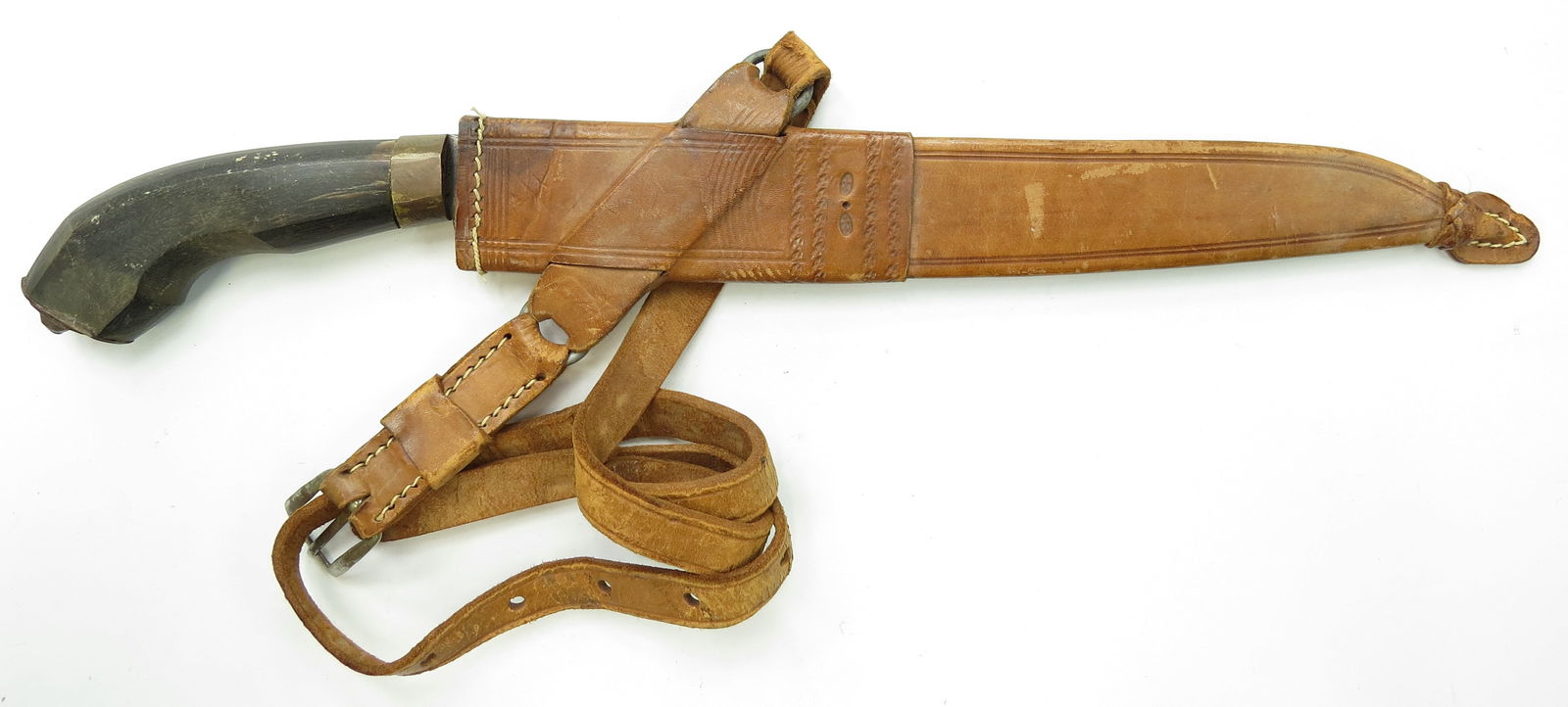 A PHILIPPINES BOLO KNIFE: Of Luzon Tabak type, with heavy handwrought blade and horn grip. In its leather scabbard with tooled and profiled mounts. Retains its belt. Early 20th century. Well worn. Overall length 44cm/ 17 3/8 i